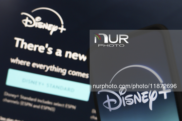 The Disney Plus logo appears on a smartphone screen next to a login screen with email and password in Reno, United States, on December 15, 2...