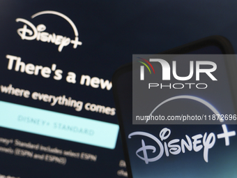 The Disney Plus logo appears on a smartphone screen next to a login screen with email and password in Reno, United States, on December 15, 2...