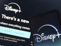 The Disney Plus logo appears on a smartphone screen next to a login screen with email and password in Reno, United States, on December 15, 2...