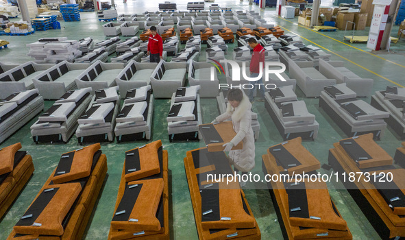 A worker produces sofas for sale to Europe and the United States in a furniture workshop in Suqian, Jiangsu province, China, on December 15,...