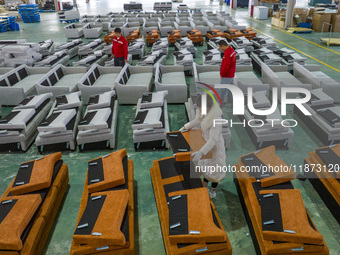 A worker produces sofas for sale to Europe and the United States in a furniture workshop in Suqian, Jiangsu province, China, on December 15,...