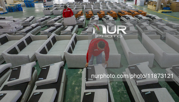 A worker produces sofas for sale to Europe and the United States in a furniture workshop in Suqian, Jiangsu province, China, on December 15,...