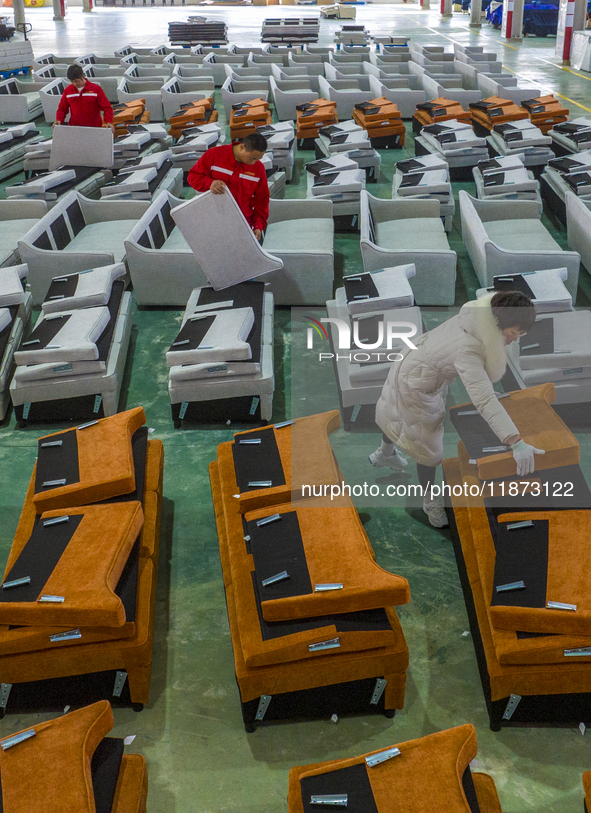 A worker produces sofas for sale to Europe and the United States in a furniture workshop in Suqian, Jiangsu province, China, on December 15,...