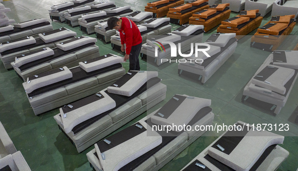 A worker produces sofas for sale to Europe and the United States in a furniture workshop in Suqian, Jiangsu province, China, on December 15,...