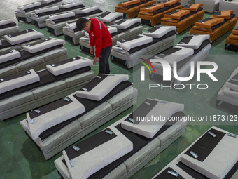 A worker produces sofas for sale to Europe and the United States in a furniture workshop in Suqian, Jiangsu province, China, on December 15,...