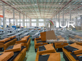 A worker produces sofas for sale to Europe and the United States in a furniture workshop in Suqian, Jiangsu province, China, on December 15,...