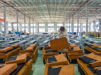 A worker produces sofas for sale to Europe and the United States in a furniture workshop in Suqian, Jiangsu province, China, on December 15,...