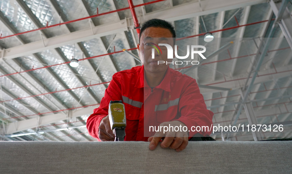 A worker produces sofas for sale to Europe and the United States in a furniture workshop in Suqian, Jiangsu province, China, on December 15,...