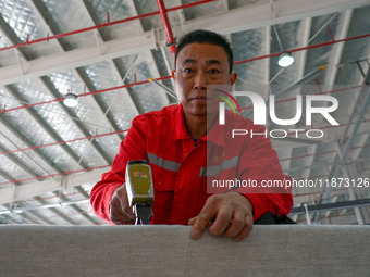 A worker produces sofas for sale to Europe and the United States in a furniture workshop in Suqian, Jiangsu province, China, on December 15,...