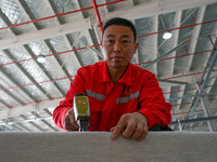 A worker produces sofas for sale to Europe and the United States in a furniture workshop in Suqian, Jiangsu province, China, on December 15,...