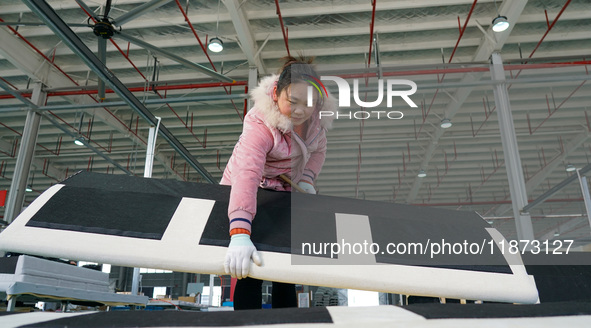 A worker produces sofas for sale to Europe and the United States in a furniture workshop in Suqian, Jiangsu province, China, on December 15,...