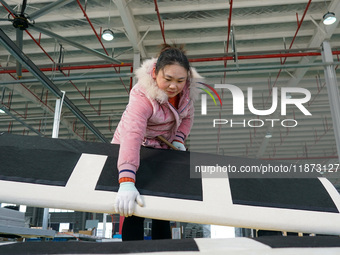 A worker produces sofas for sale to Europe and the United States in a furniture workshop in Suqian, Jiangsu province, China, on December 15,...