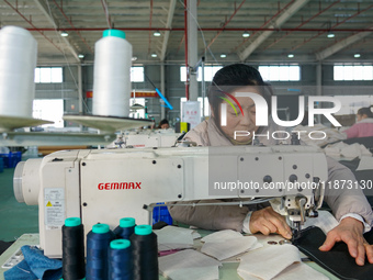 A worker produces sofas for sale to Europe and the United States in a furniture workshop in Suqian, Jiangsu province, China, on December 15,...