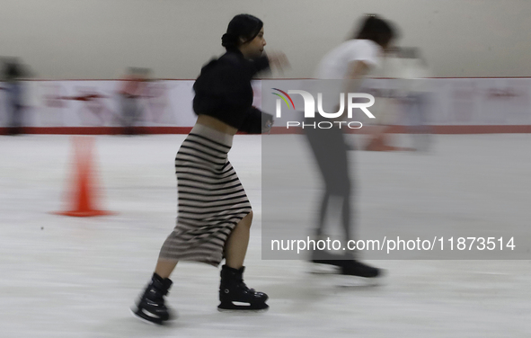 Attendees visit an ice rink in a Christmas village set up in the Tlahuac Forest in Mexico City on December 15, 2024. 