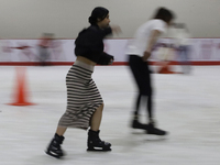 Attendees visit an ice rink in a Christmas village set up in the Tlahuac Forest in Mexico City on December 15, 2024. (