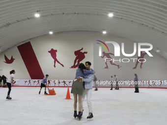 Attendees visit an ice rink in a Christmas village set up in the Tlahuac Forest in Mexico City on December 15, 2024. (