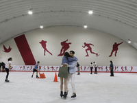 Attendees visit an ice rink in a Christmas village set up in the Tlahuac Forest in Mexico City on December 15, 2024. (