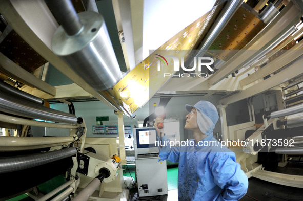 A worker works on the production line of a pharmaceutical packaging workshop in Lianyungang, China, on December 16, 2024. 