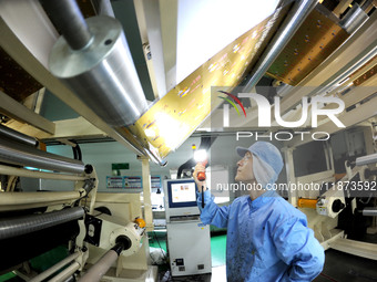 A worker works on the production line of a pharmaceutical packaging workshop in Lianyungang, China, on December 16, 2024. (