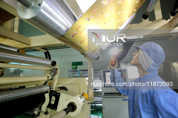 A worker works on the production line of a pharmaceutical packaging workshop in Lianyungang, China, on December 16, 2024. 