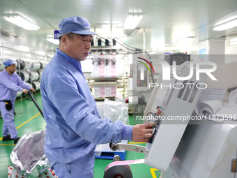 A worker works on the production line of a pharmaceutical packaging workshop in Lianyungang, China, on December 16, 2024. (