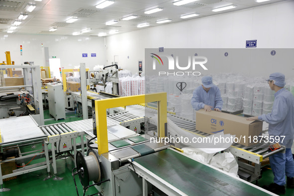 Workers work on the production line of a pharmaceutical packaging workshop in Lianyungang, Jiangsu province, China, on December 16, 2024. 