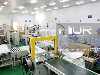 Workers work on the production line of a pharmaceutical packaging workshop in Lianyungang, Jiangsu province, China, on December 16, 2024. (