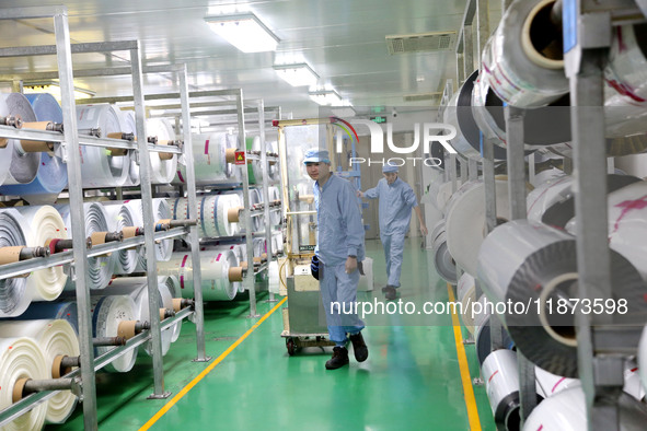 A worker works on the production line of a pharmaceutical packaging workshop in Lianyungang, China, on December 16, 2024. 