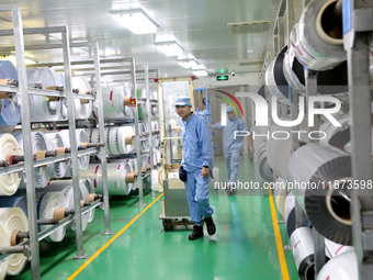 A worker works on the production line of a pharmaceutical packaging workshop in Lianyungang, China, on December 16, 2024. (