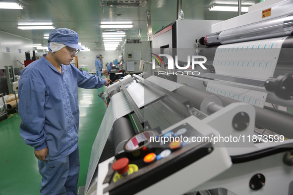 A worker works on the production line of a pharmaceutical packaging workshop in Lianyungang, China, on December 16, 2024. 