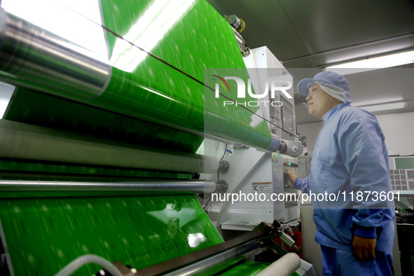 A worker works on the production line of a pharmaceutical packaging workshop in Lianyungang, China, on December 16, 2024. 