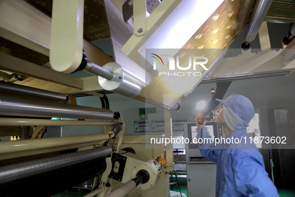 A worker works on the production line of a pharmaceutical packaging workshop in Lianyungang, China, on December 16, 2024. 