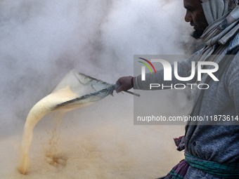 Workers prepare date jaggery after collecting juice from date palm trees in Magura, Bangladesh, on January 16, 2024. The production of date...