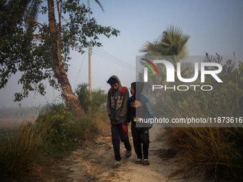 Boys walk along a village road on a winter morning in Magura, Bangladesh, on December 16, 2024. (