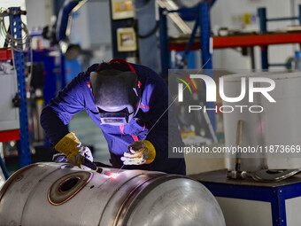 A worker works at a workshop of a water supply equipment manufacturing company in Qingzhou, China, on December 16, 2024. (