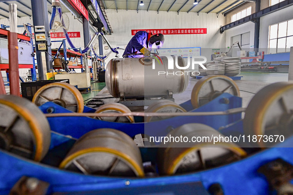 A worker works at a workshop of a water supply equipment manufacturing company in Qingzhou, China, on December 16, 2024. 