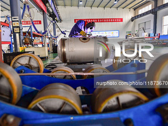 A worker works at a workshop of a water supply equipment manufacturing company in Qingzhou, China, on December 16, 2024. (