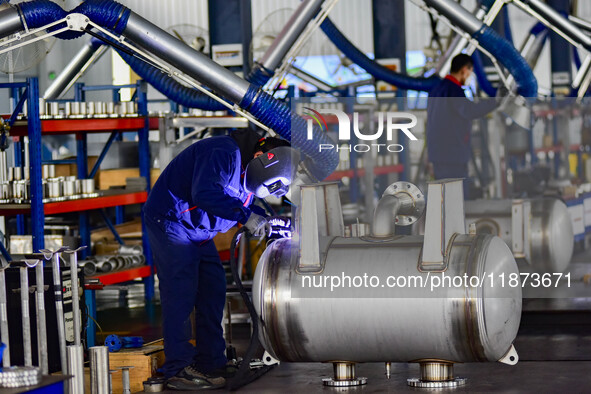 A worker works at a workshop of a water supply equipment manufacturing company in Qingzhou, China, on December 16, 2024. 