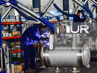 A worker works at a workshop of a water supply equipment manufacturing company in Qingzhou, China, on December 16, 2024. (