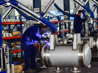 A worker works at a workshop of a water supply equipment manufacturing company in Qingzhou, China, on December 16, 2024. (