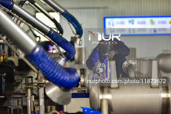 A worker works at a workshop of a water supply equipment manufacturing company in Qingzhou, China, on December 16, 2024. 