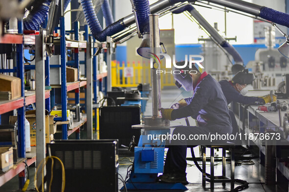 A worker works at a workshop of a water supply equipment manufacturing company in Qingzhou, China, on December 16, 2024. 