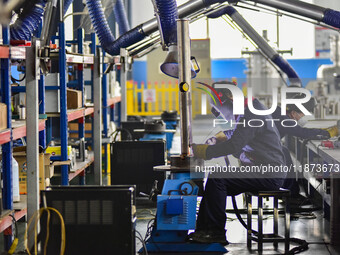 A worker works at a workshop of a water supply equipment manufacturing company in Qingzhou, China, on December 16, 2024. (