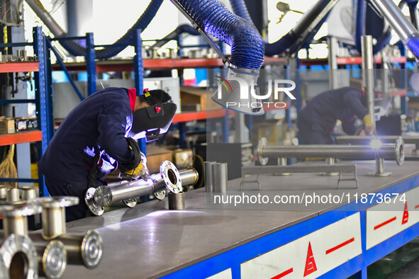 A worker works at a workshop of a water supply equipment manufacturing company in Qingzhou, China, on December 16, 2024. 