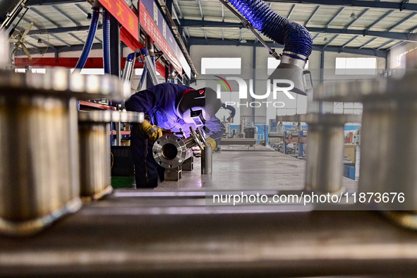 A worker works at a workshop of a water supply equipment manufacturing company in Qingzhou, China, on December 16, 2024. 