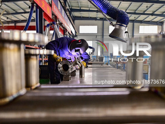 A worker works at a workshop of a water supply equipment manufacturing company in Qingzhou, China, on December 16, 2024. (