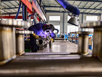 A worker works at a workshop of a water supply equipment manufacturing company in Qingzhou, China, on December 16, 2024. (