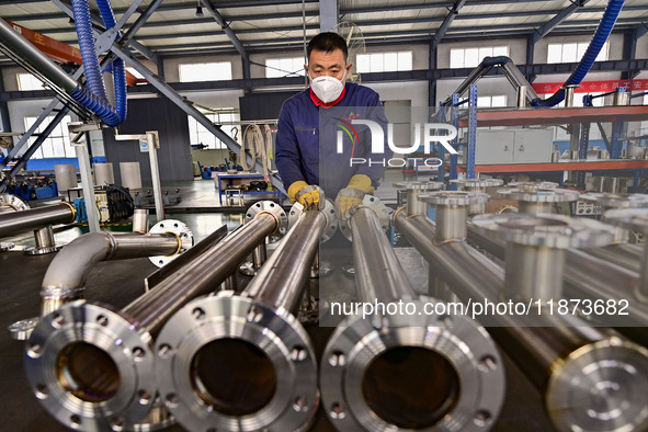 A worker works at a workshop of a water supply equipment manufacturing company in Qingzhou, China, on December 16, 2024. 