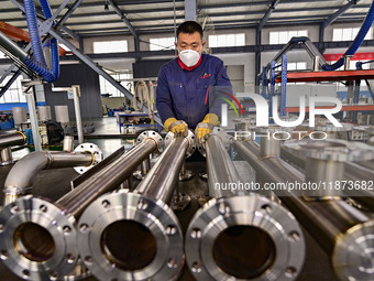 A worker works at a workshop of a water supply equipment manufacturing company in Qingzhou, China, on December 16, 2024. (