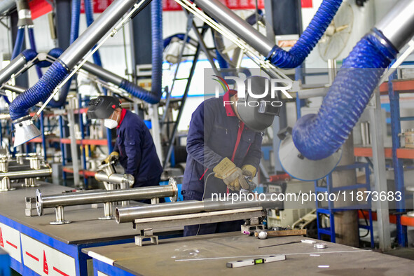 A worker works at a workshop of a water supply equipment manufacturing company in Qingzhou, China, on December 16, 2024. 